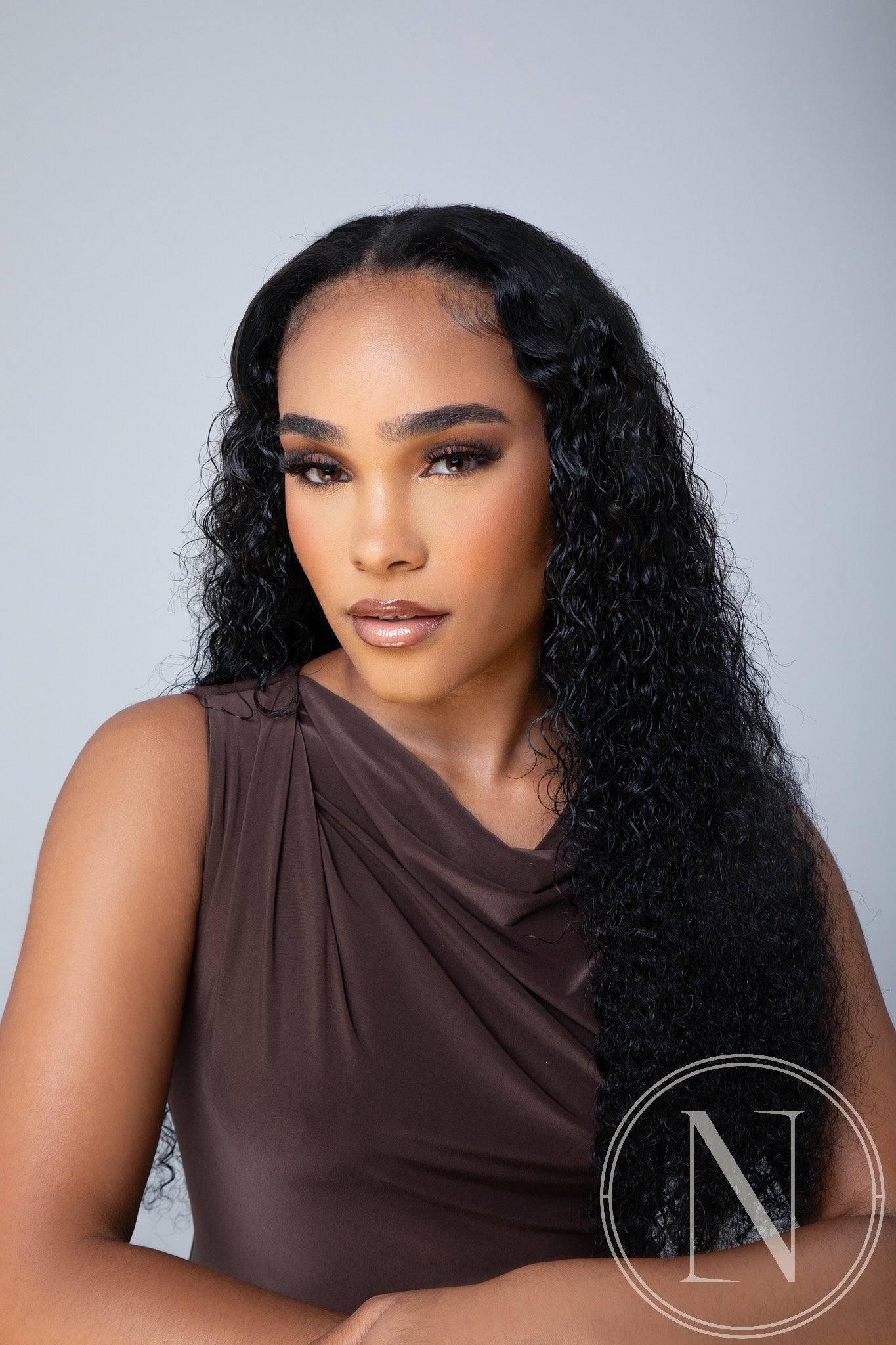 NuNaLa UPart curly half wig in natural black, front view showing seamless blend with natural hair on model